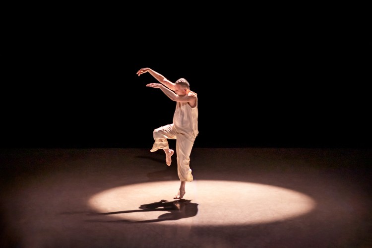 A man in white affects a stork stance